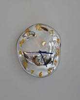 Closeup details of the Silje Lindrup Yellow Glass Wall Clock on wall.