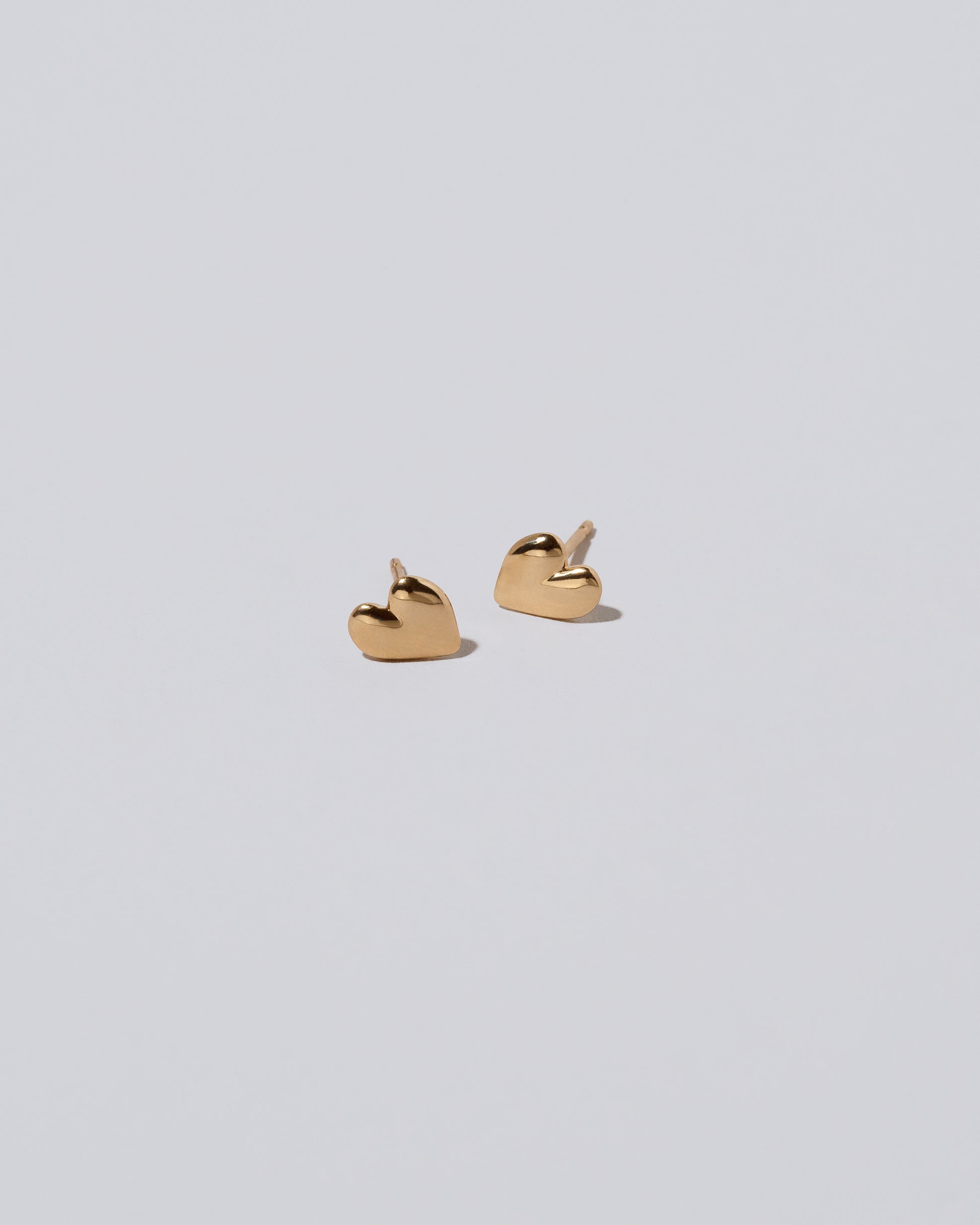 Gold Small Thousand & One Night Heart Stud Earrings on light color background.