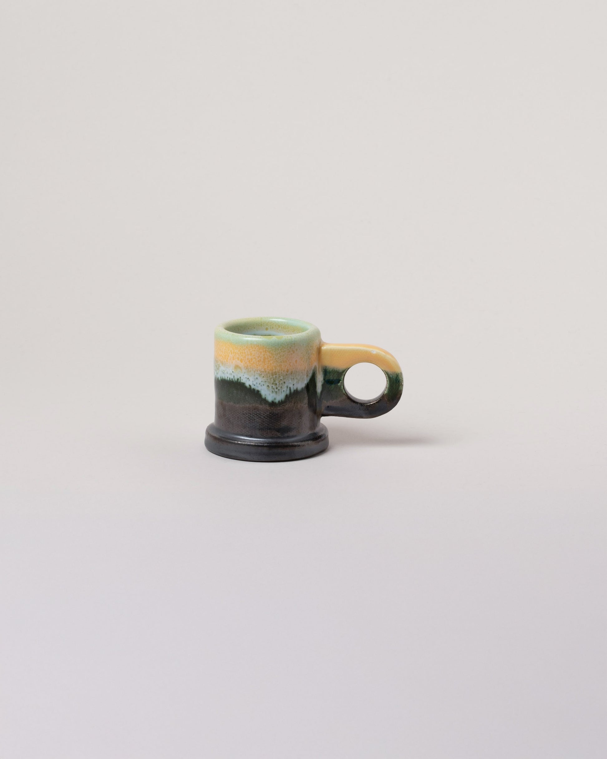 Echo Park Pottery by Peter Shire Blue, Yellow & Gunmetal Double Dip Espresso Mug on light color background.