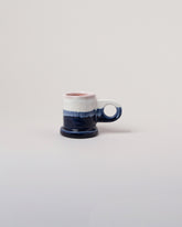 Echo Park Pottery by Peter Shire White & Navy Double Dip Espresso Mug on light color background.