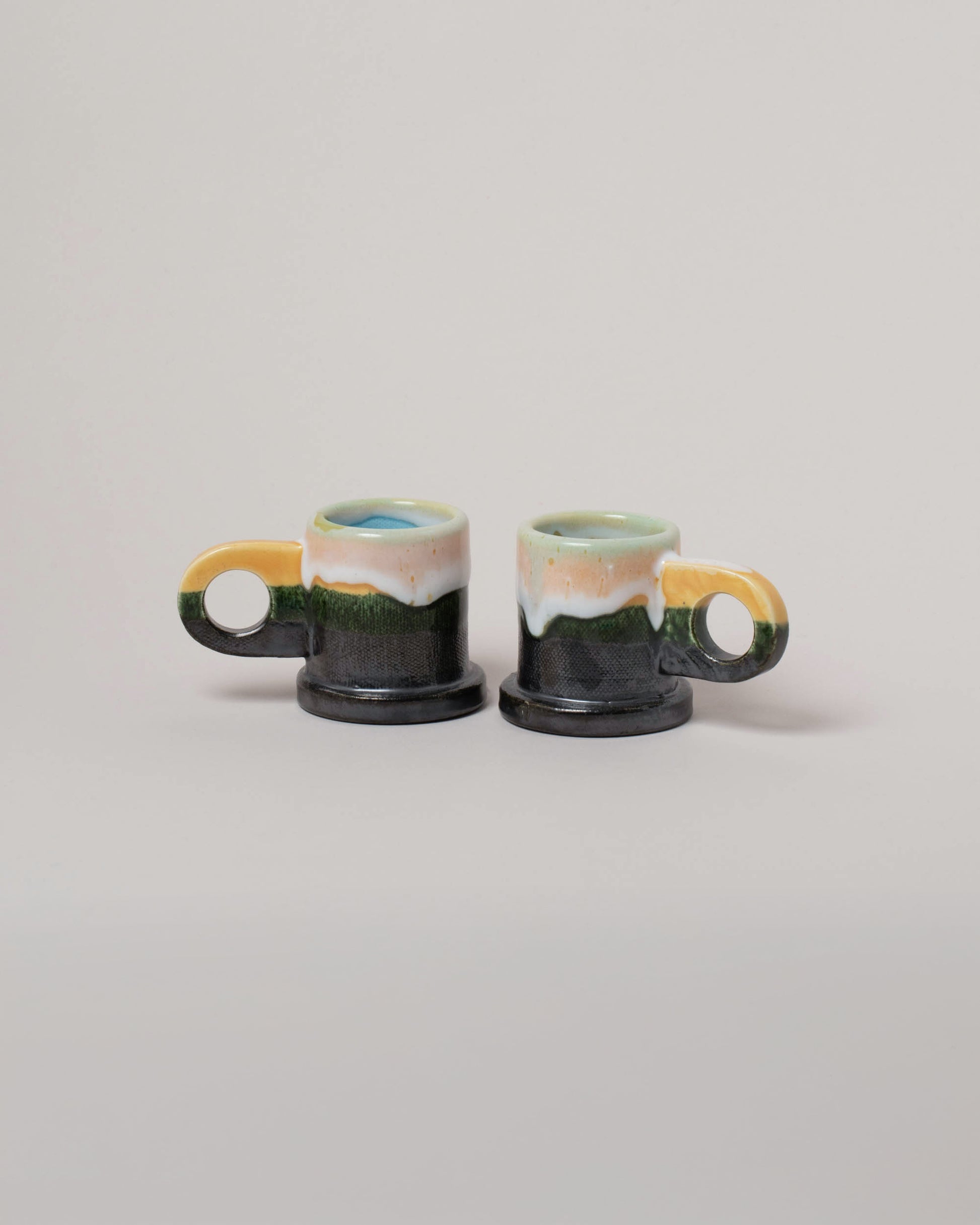 Echo Park Pottery by Peter Shire Yellow & Gunmetal Double Dip Espresso Mug Set on light color background.