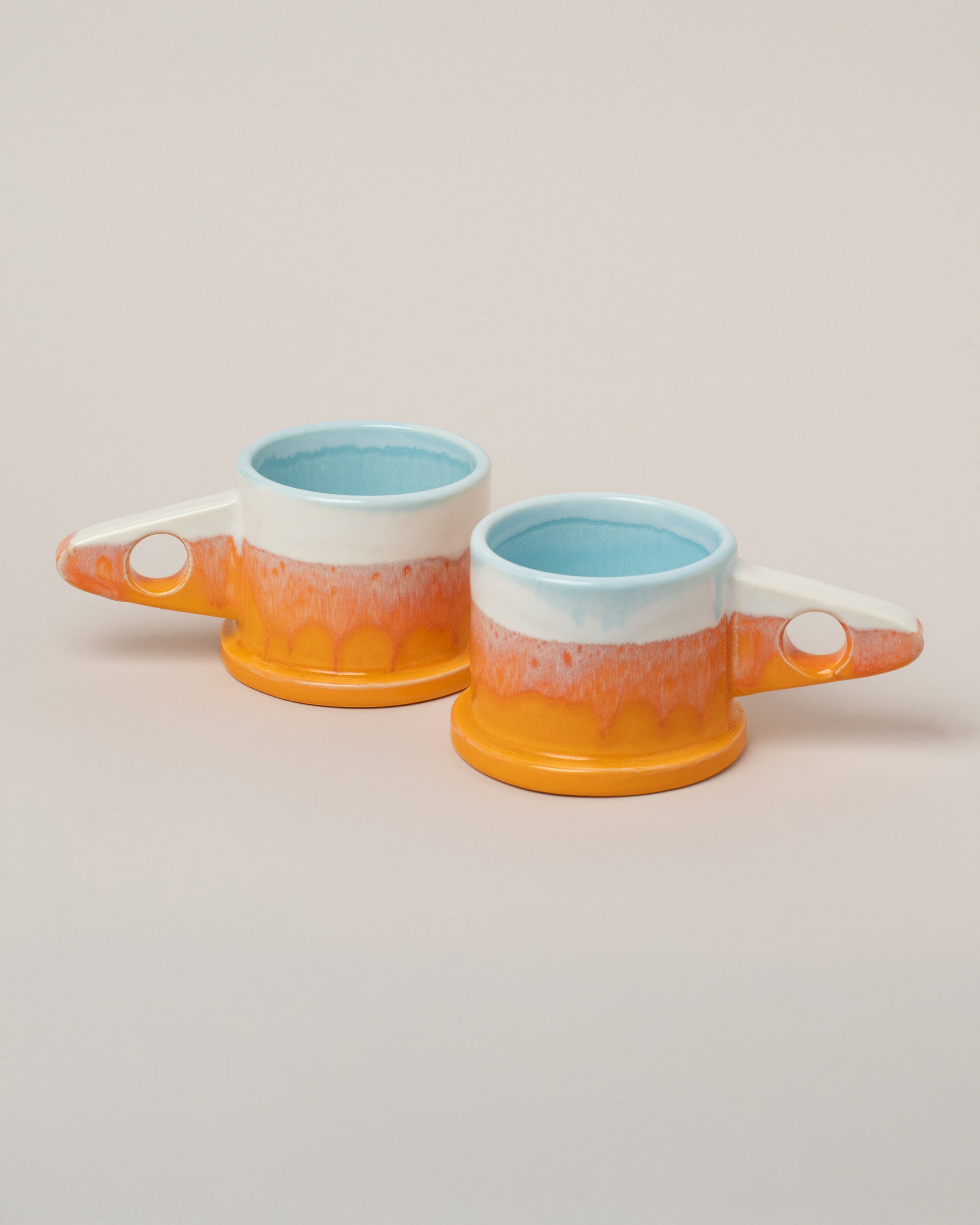 Echo Park Pottery by Peter Shire White & Orange Double Dip Mug Set on light color background.