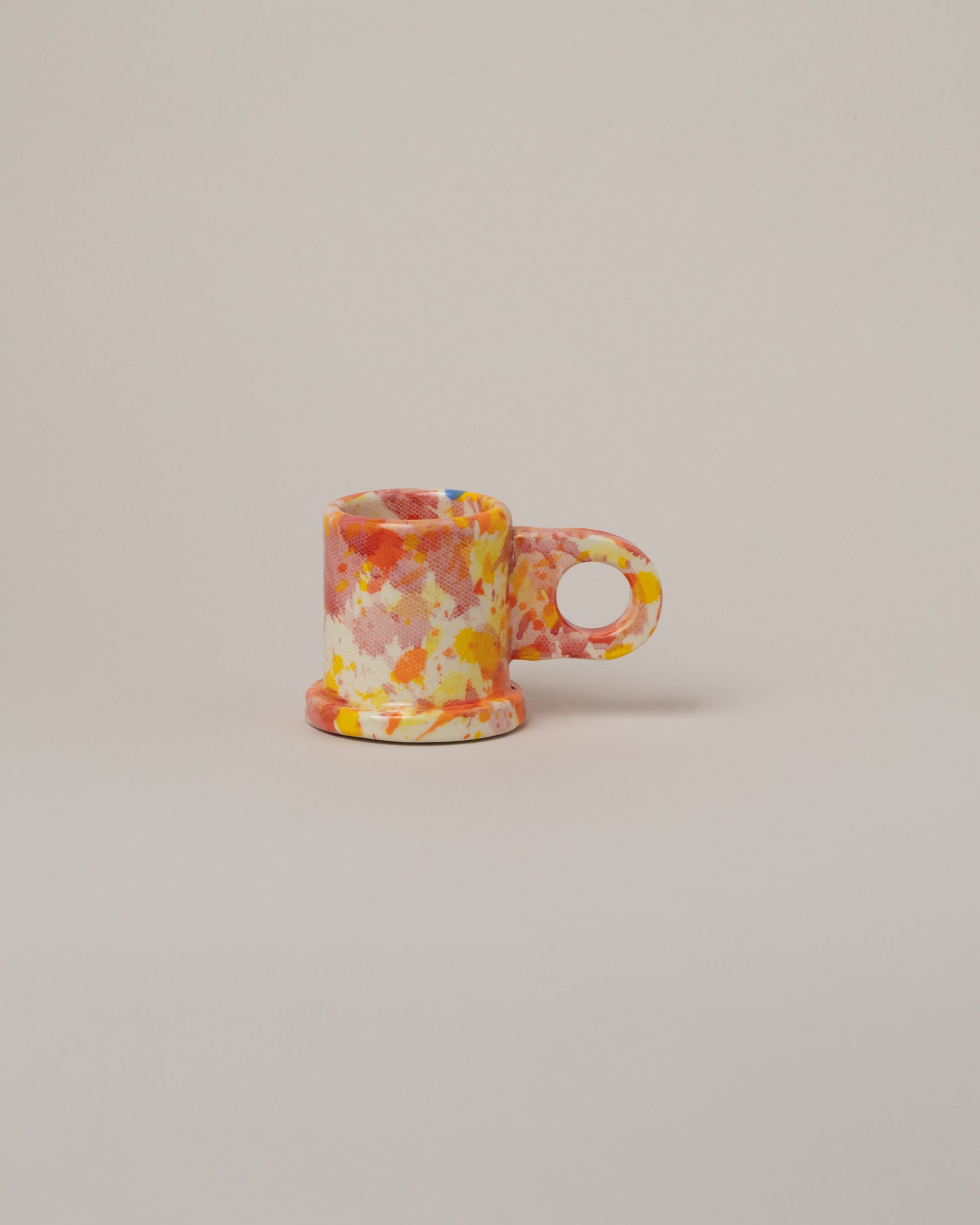 Echo Park Pottery by Peter Shire Orange & Pink Splatter Espresso Mug on light color background.