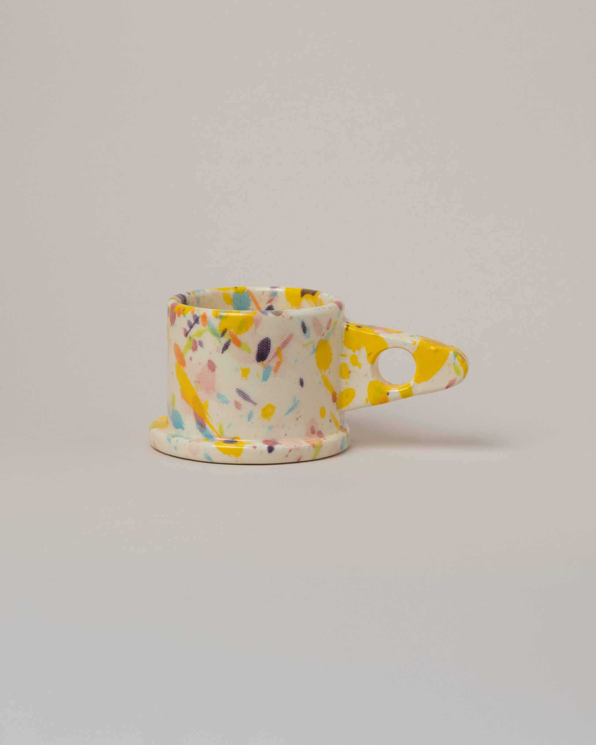 Echo Park Pottery by Peter Shire Yellow & Purple Splatter Mug on light color background.