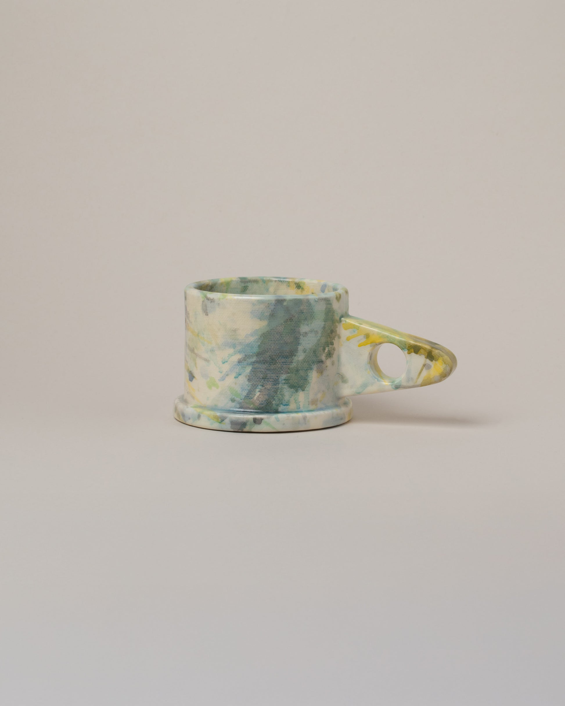 Echo Park Pottery by Peter Shire Yellow & Green Splatter Mug on light color background.
