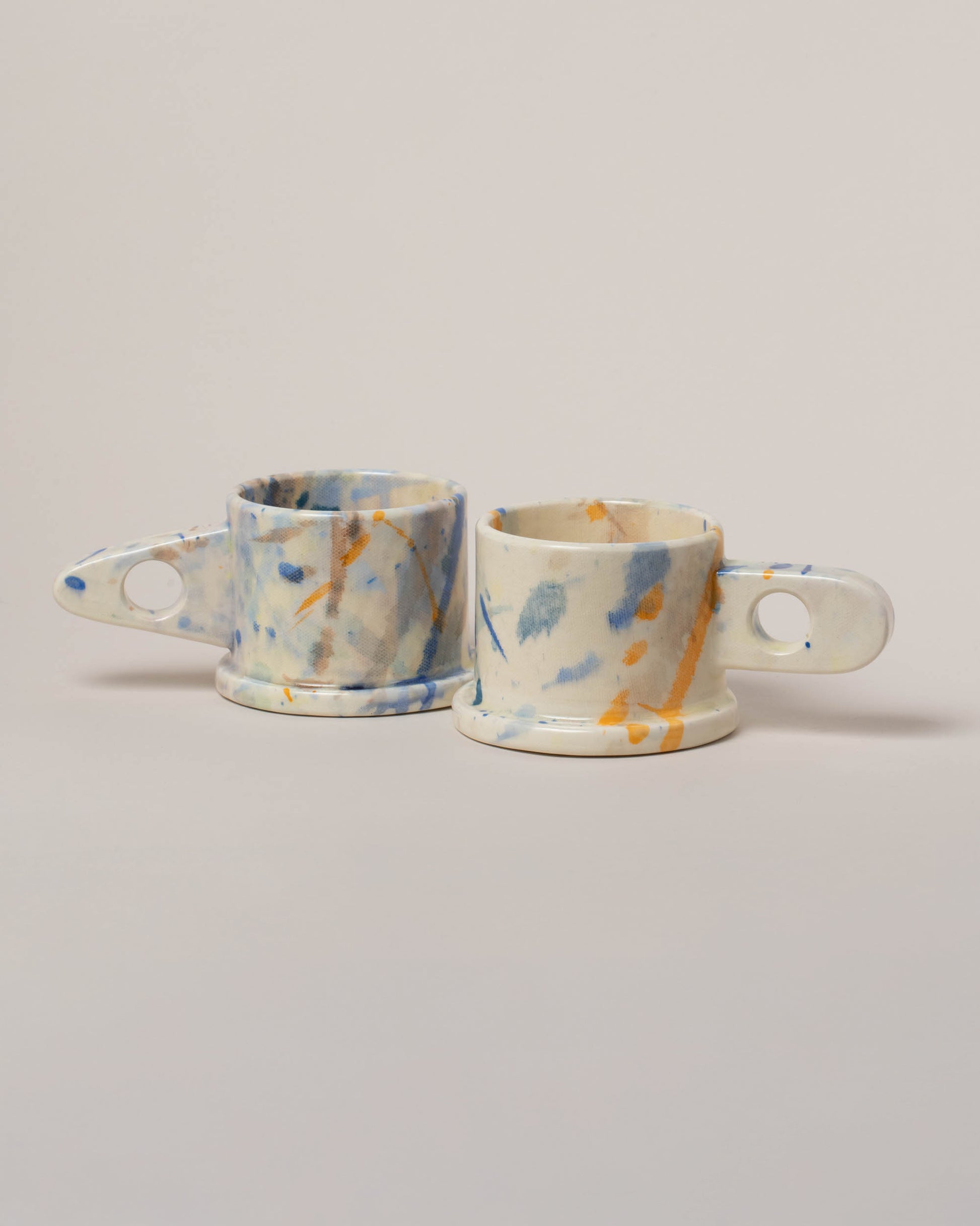 Echo Park Pottery by Peter Shire White & Blue Splatter Mug Set on light color background.