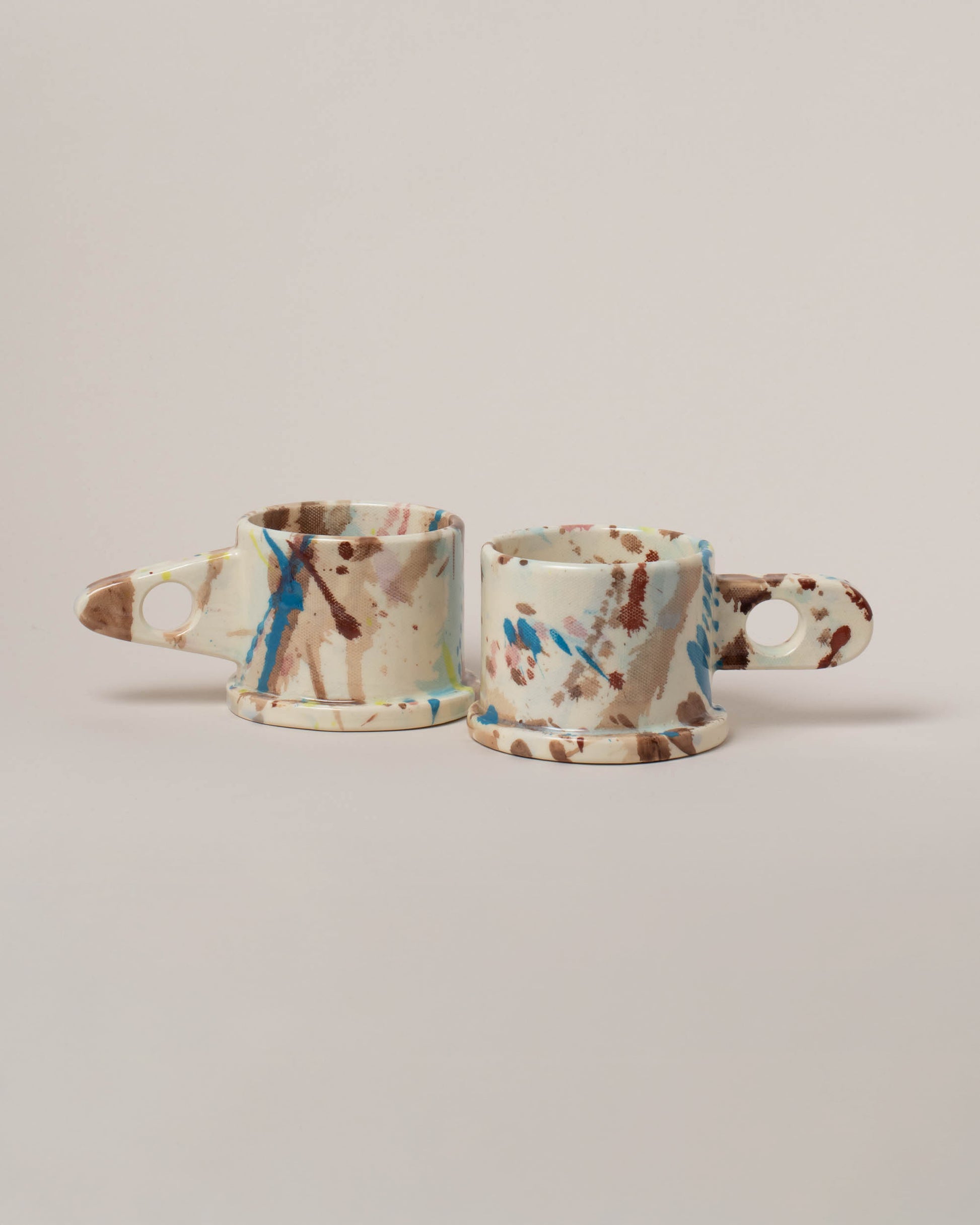 Echo Park Pottery by Peter Shire White & Brown Splatter Mug Set on light color background.