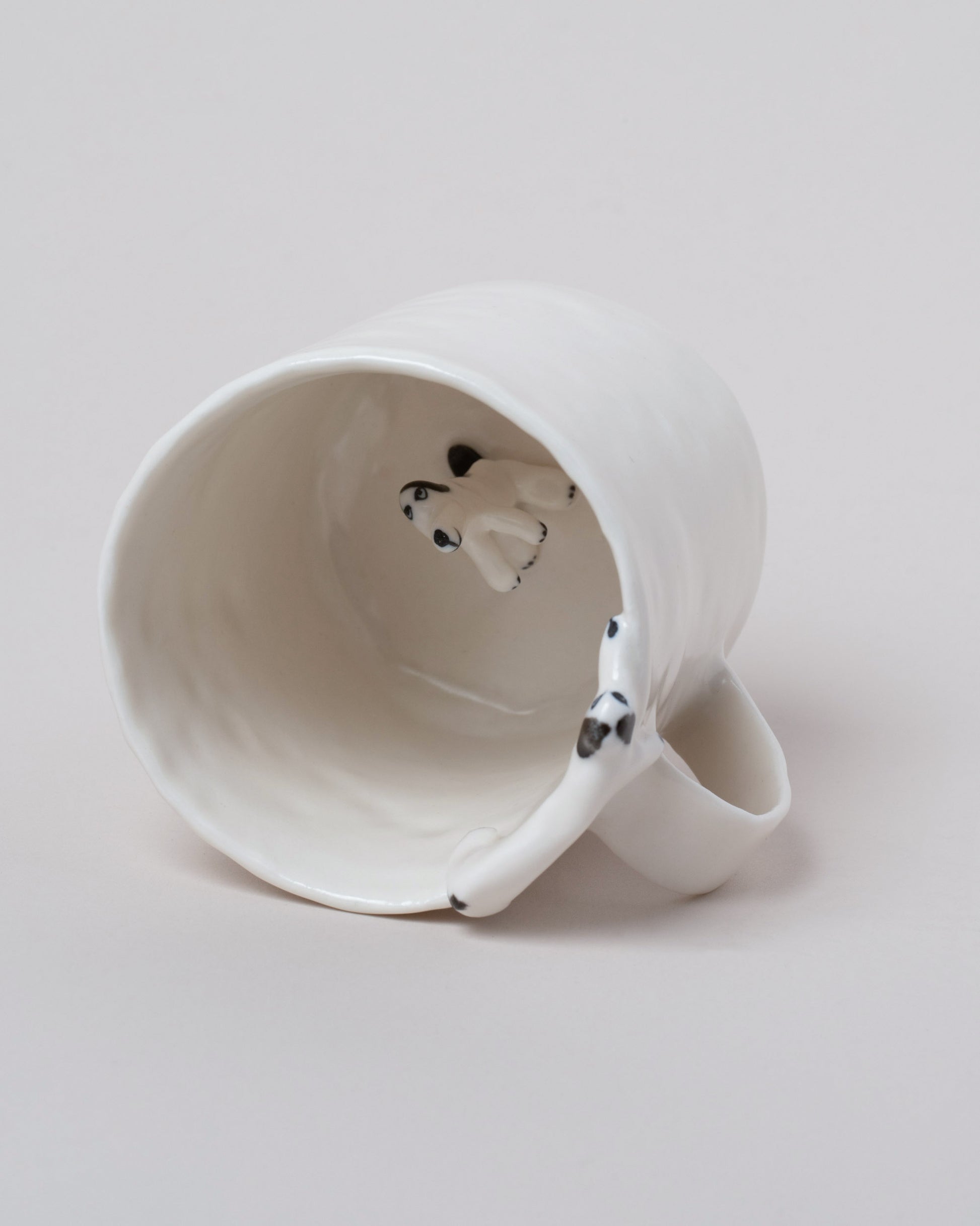 Inside view of the Eleonor Boström Hiding Dog Mug on light color background.