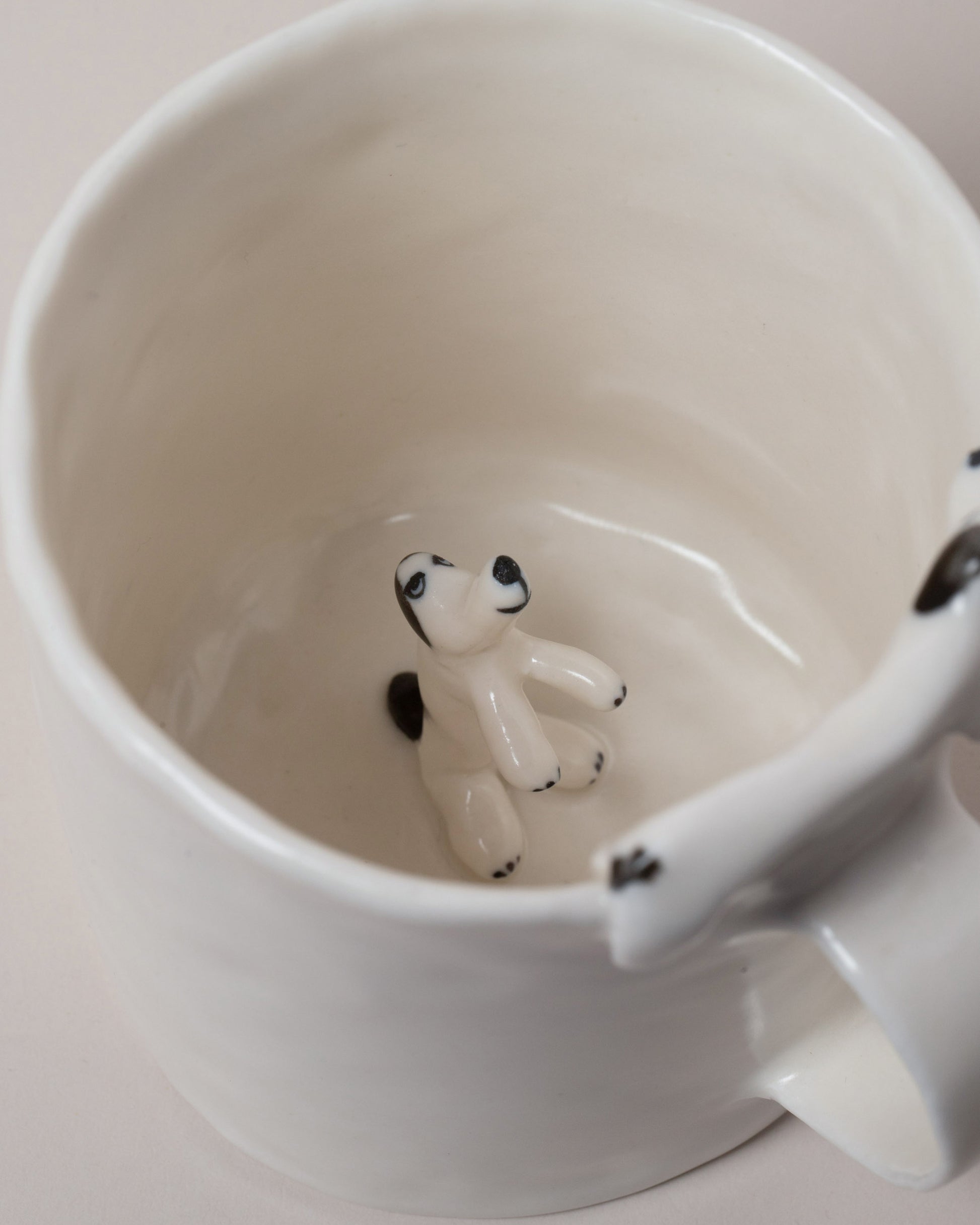 Closeup details of the Eleonor Boström Hiding Dog Mug on light color background.
