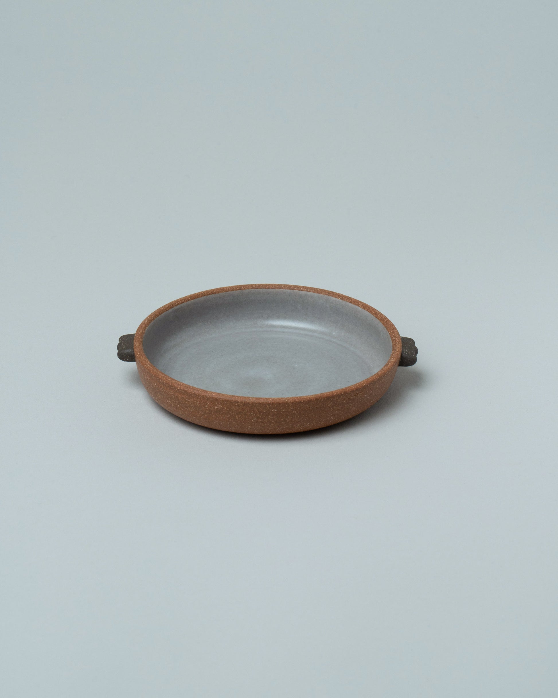 Emris Brick Clay Saucer on light color background.