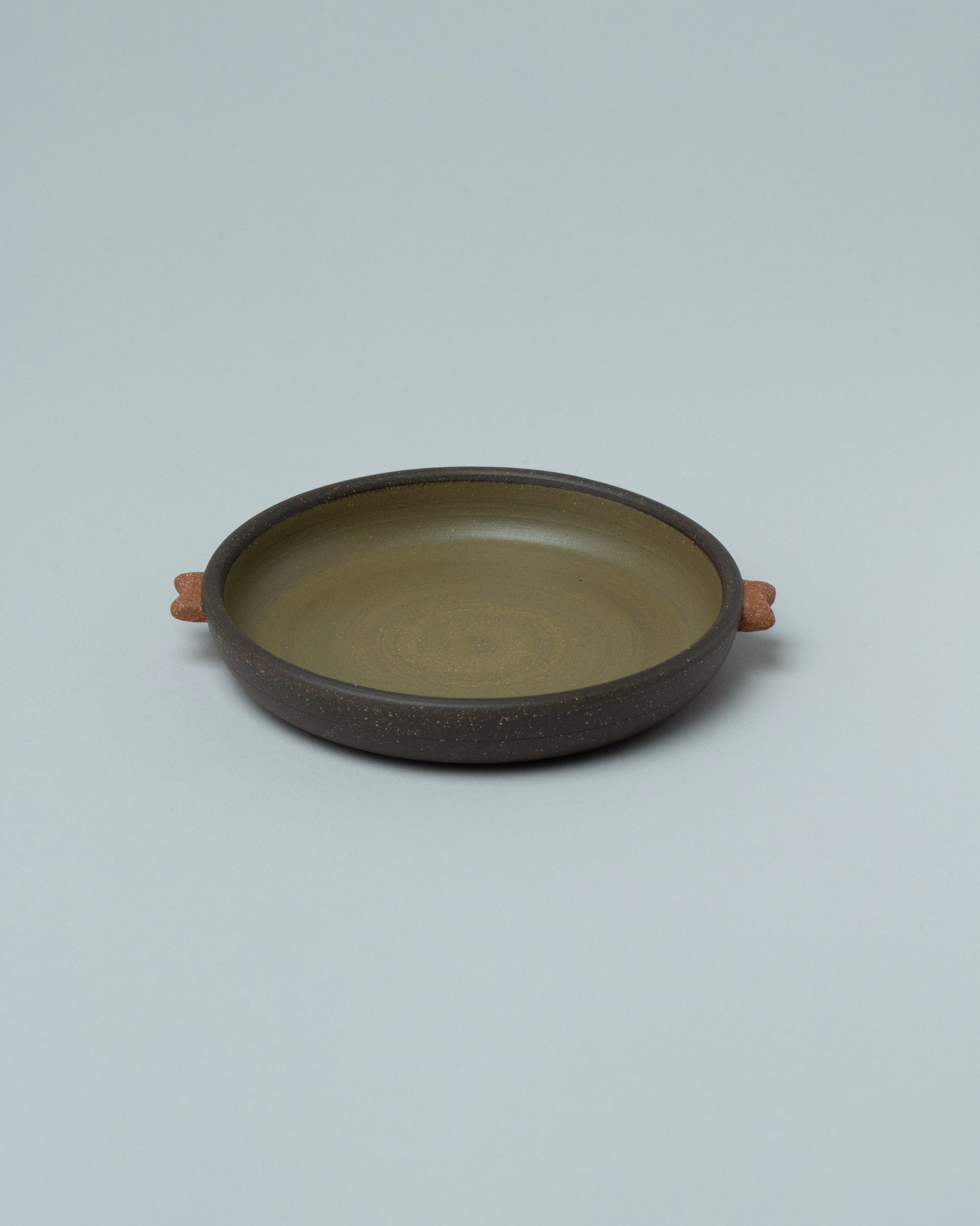 Emris Dark Stoneware Saucer on light color background.