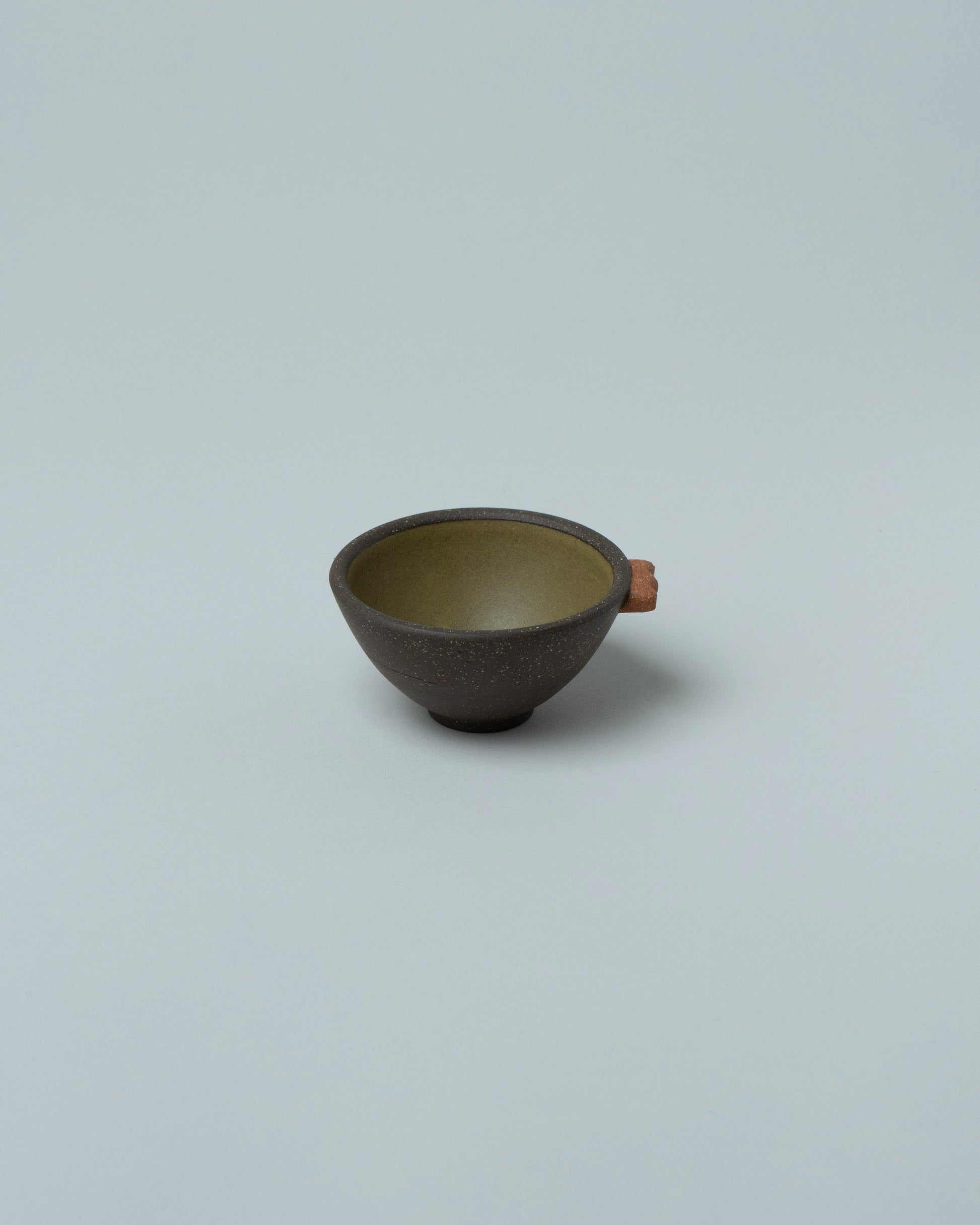 Emris Dark Stoneware Teenie Bowl on light color background.