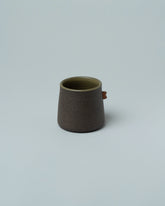 Emris Dark Stoneware Nub Cup on light color background.