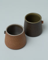 Emris Brick Clay Nub Cup and Emris Dark Stoneware Nub Cup on light color background.