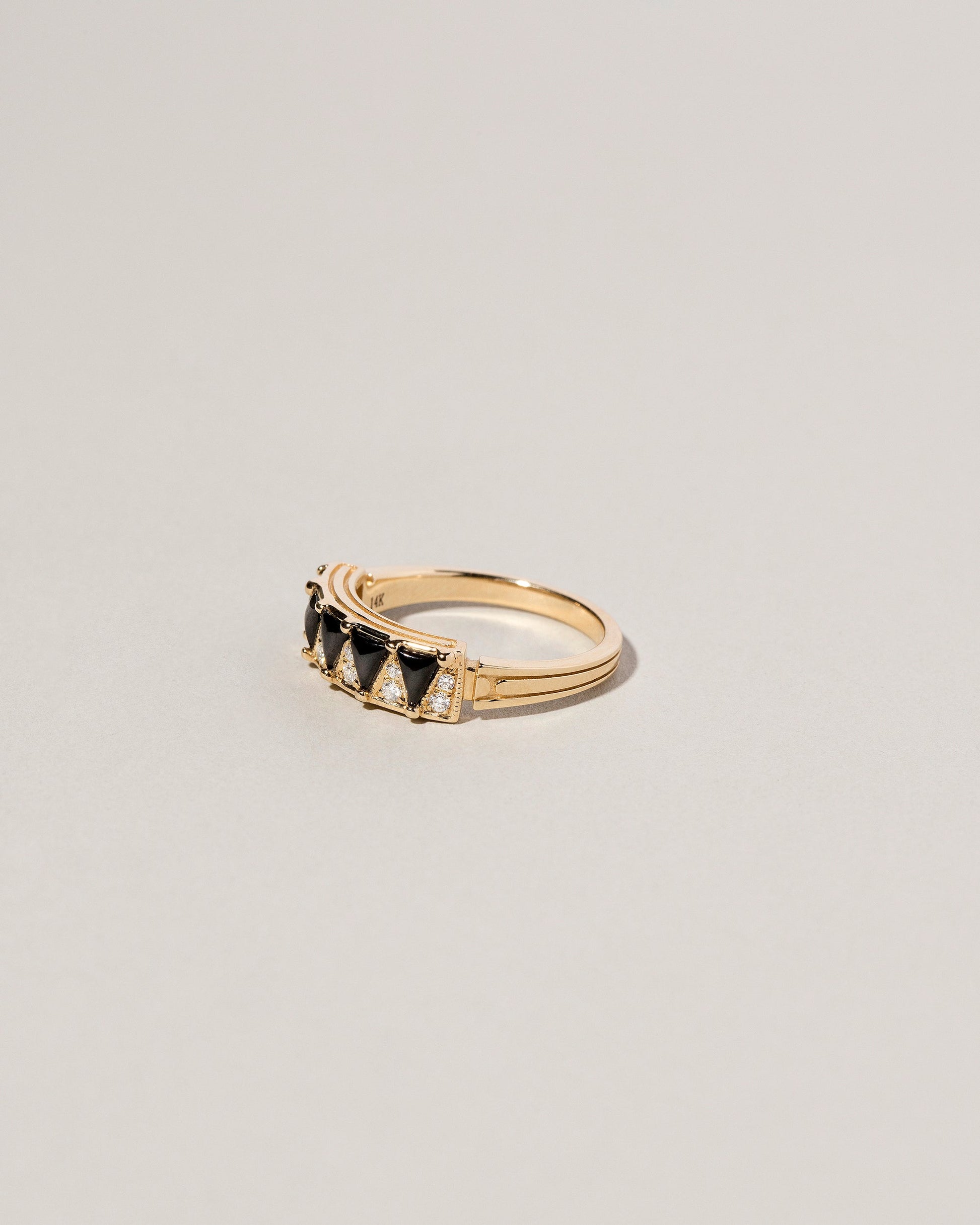 View from the side of the Gold Black Spinel Five Triangle Ring on light color background.