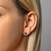 product_details::Gold Emerald Fold Earrings and Huggie Gold Diamond Snack Hoop Earrings on model.