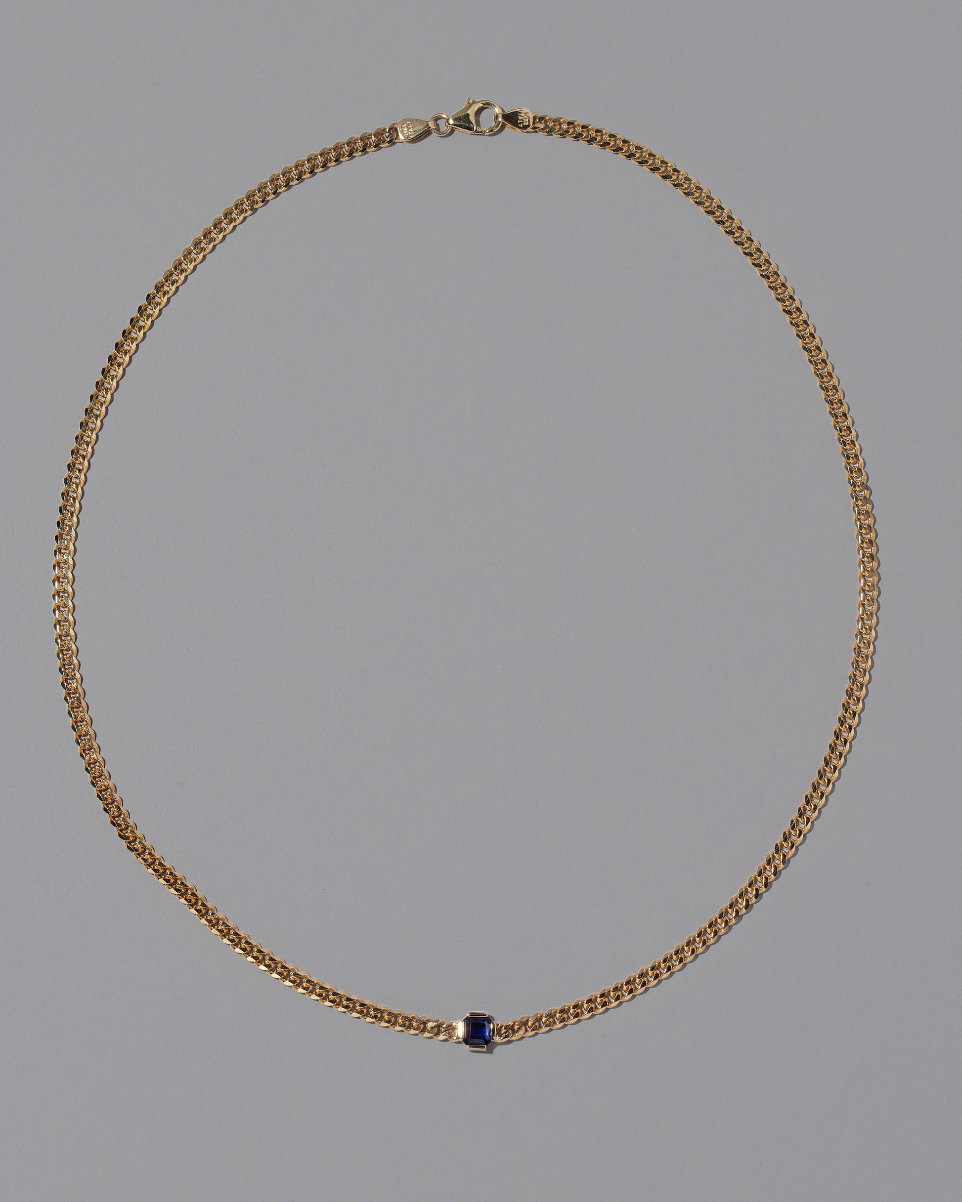 Blue Sapphire Fold Necklace on grey color background.