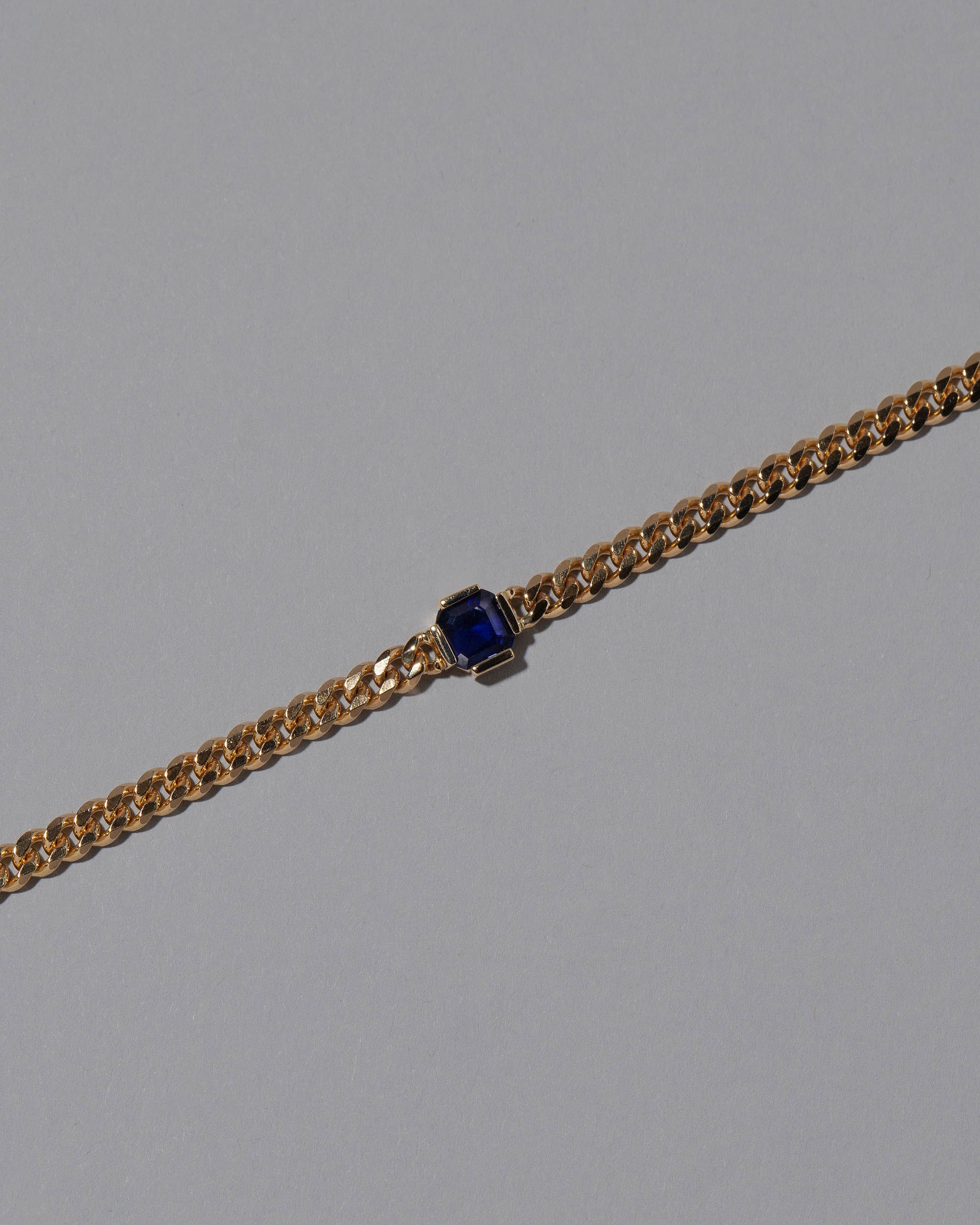 Closeup details of the Blue Sapphire Fold Bracelet on grey color background.