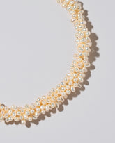 Braided Zipper Pearl Collar Necklace on light color background.