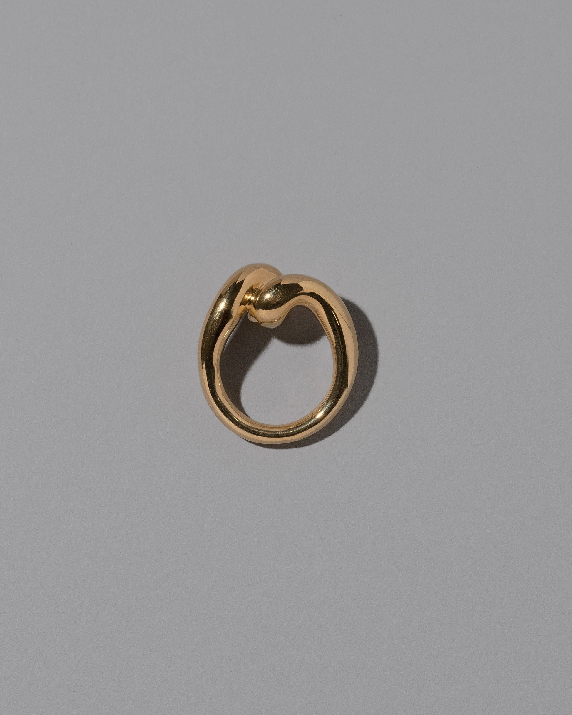 View from the side of the CRZM 22k Gold Landform Ring on light color background.