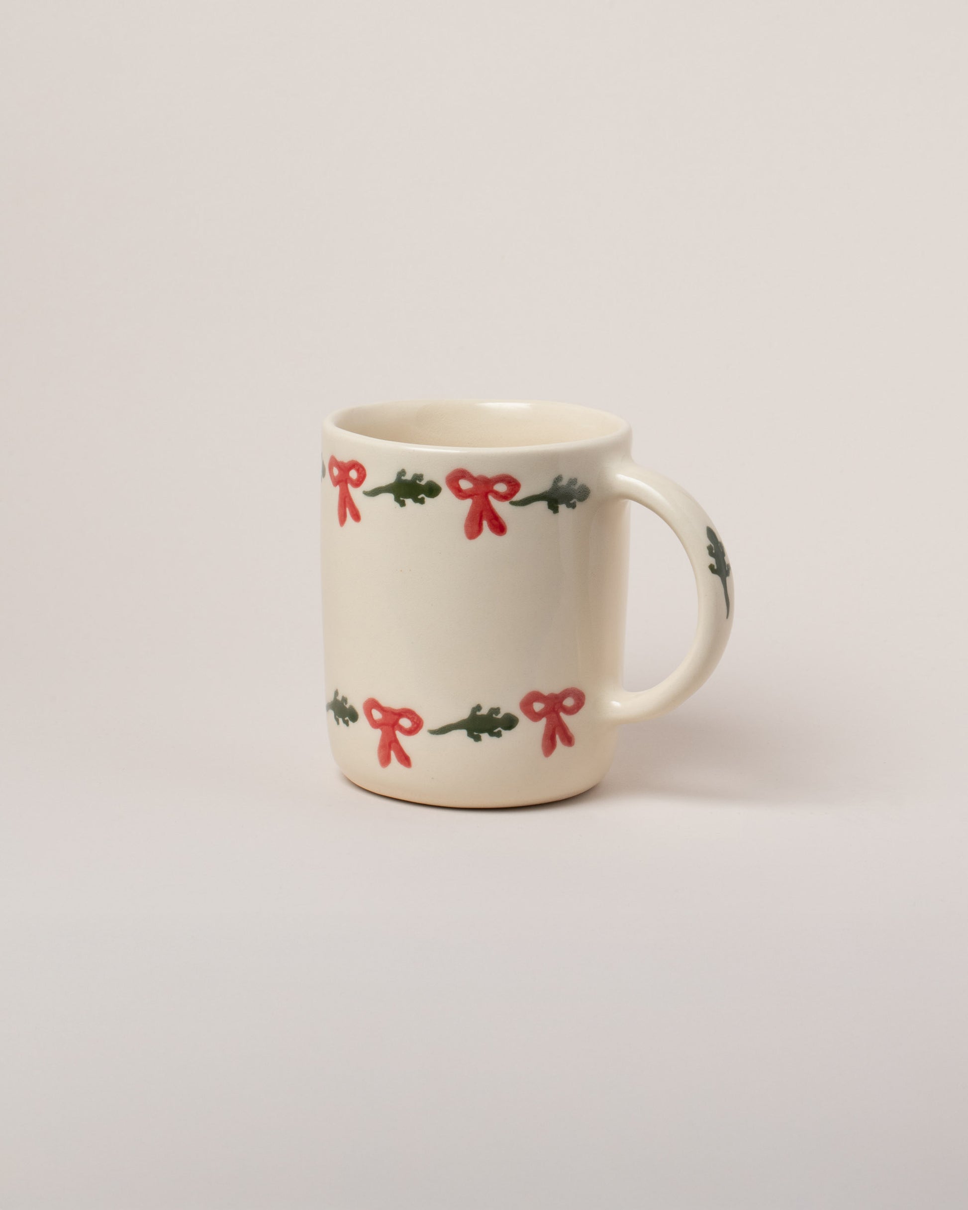 Helen Levi Lizard Christmas Mug on light color background.