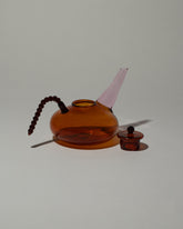 Detail view of the Ornamental by Lameice Amber & Pink Dreamlike Teapot on light color background.