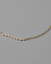 Closeup details of the Half Oval Chain & White Seed Pearl Necklace on light color background.