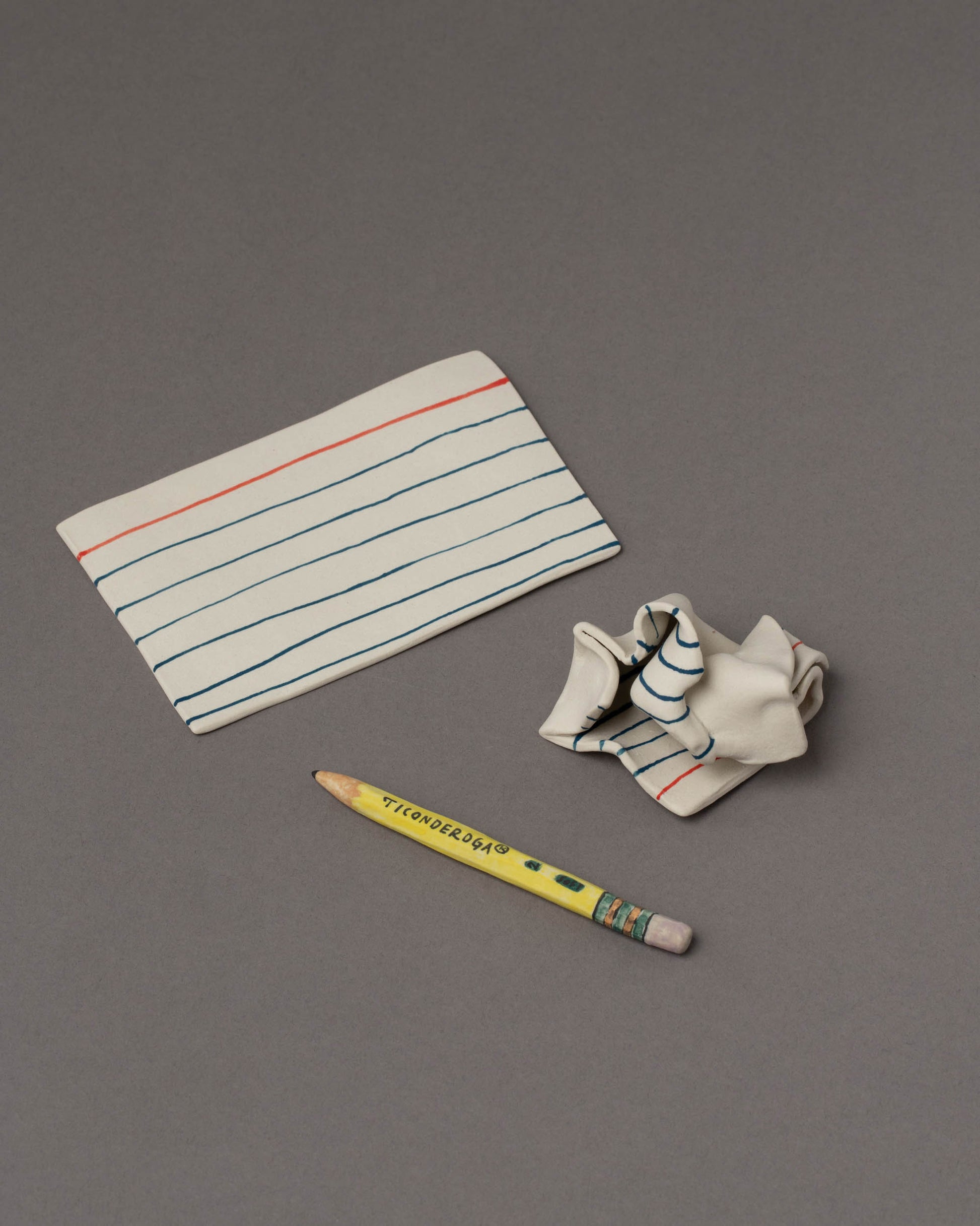 Suzanne Sullivan Pencil, Crumpled Notecard and Notecard Considering Utility Objects on grey color background.
