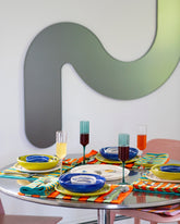 Styled image featuring the FAZEEK Clear and Teal Wave Flute Sets, Casa Veronica Leche and Azul Mini Vida Bowls, Sol and Azul Vida Bowls and Leche and Sol Vida Plates and E.E. Ceramics Smiley Serving Plate.