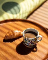 Styled image featuring the La Ceramica Vincenzo Del Monaco Colored Drops Tea Mug and Pampshade Croissant Lamp.