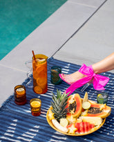 Styled image featuring the Sophie Lou Jacobsen Amber with Clear Handle Wave Pitcher, Large Amber and Large Teal Single Ripple Cups, and Ichendorft Milano Amber and Teal TAP Glasses.