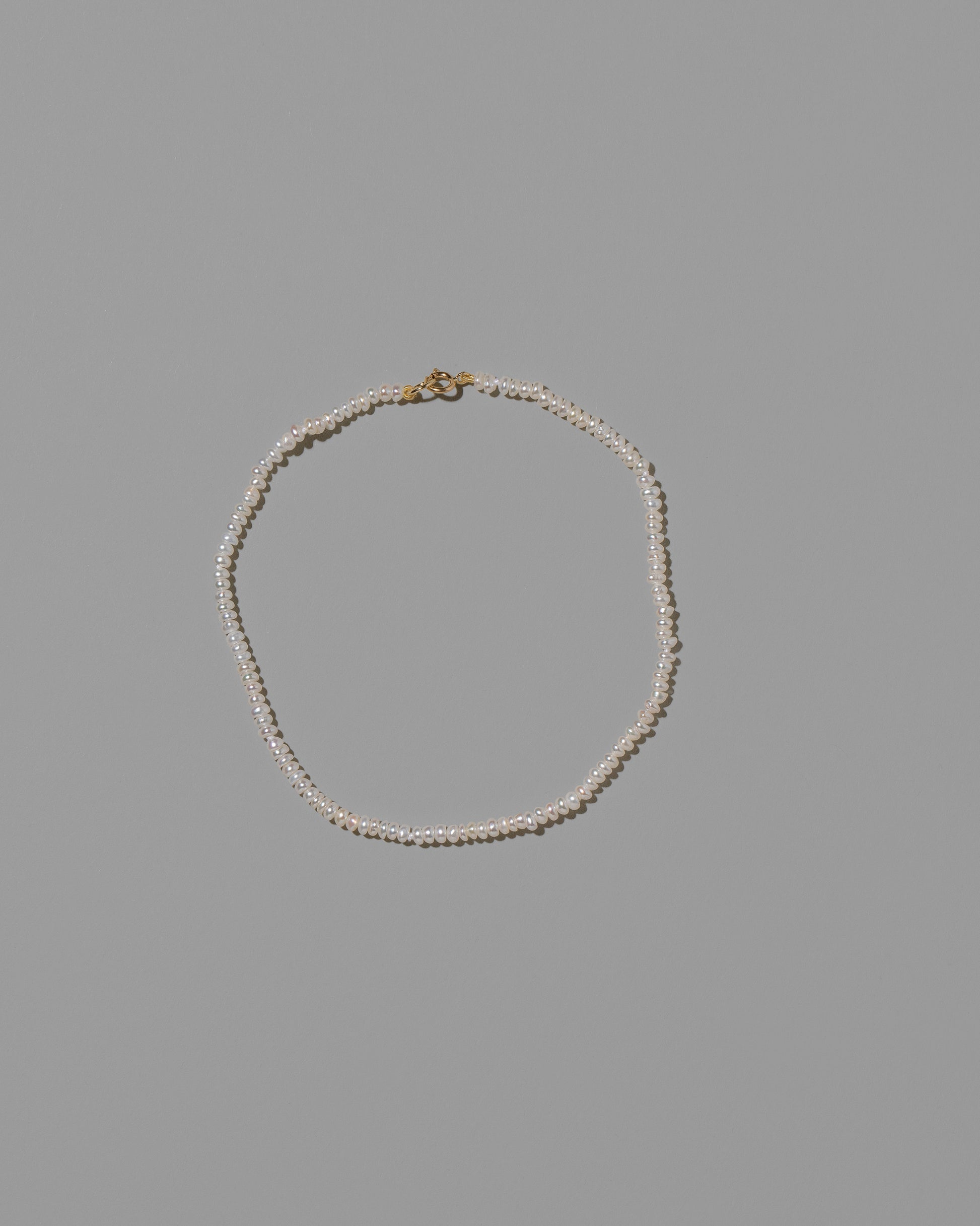 White Seed Pearl Anklet on light color background.