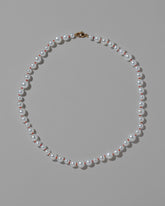 Cardinal Red Thread Bubble Pearl Necklace on light color background.