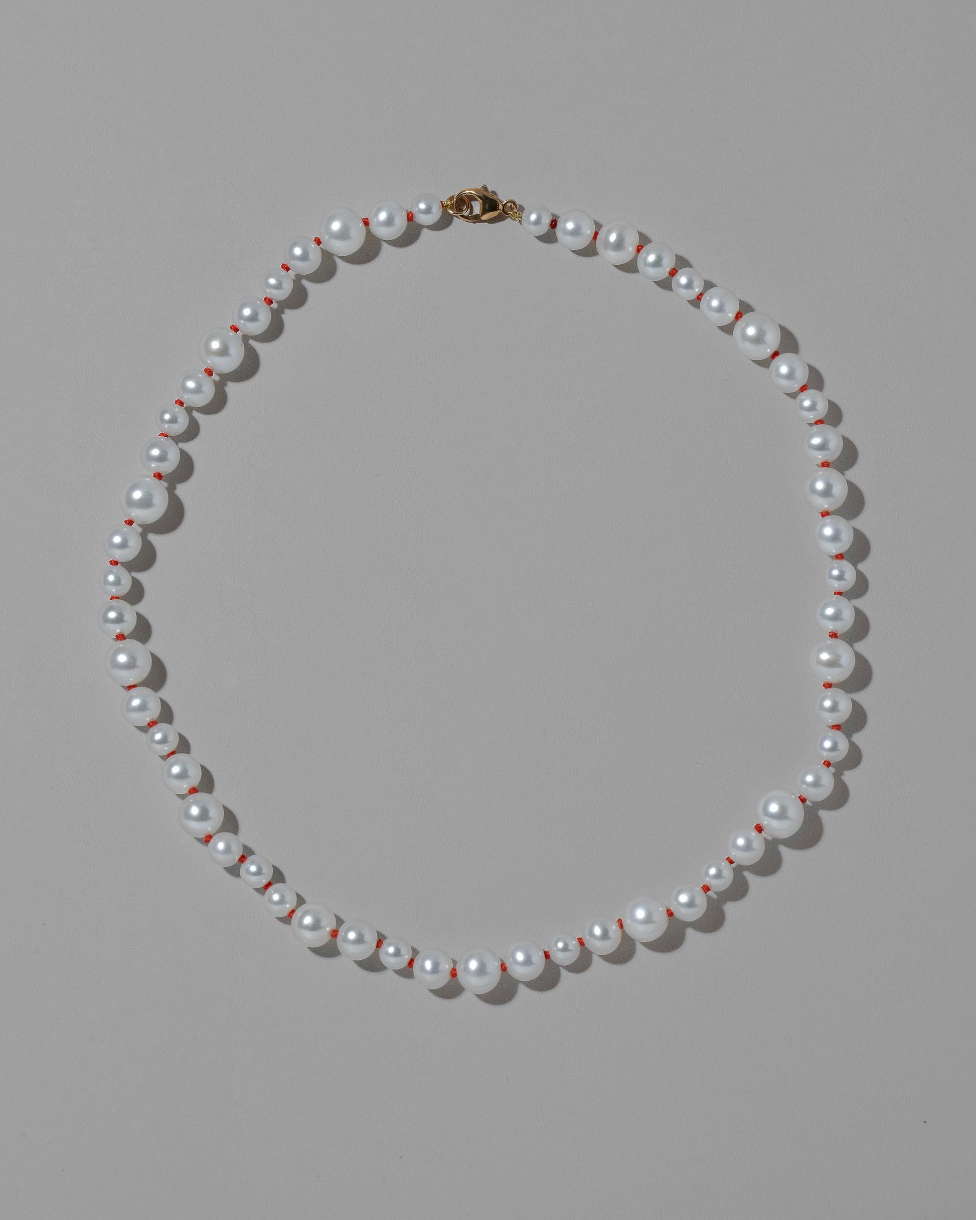 Cardinal Red Thread Bubble Pearl Necklace on light color background.