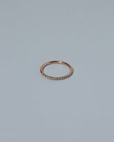 Rose Gold Fifteen Stone Diamond Dot Band on light color background.