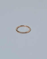 Rose Gold Five Stone Dot Band on light color background.