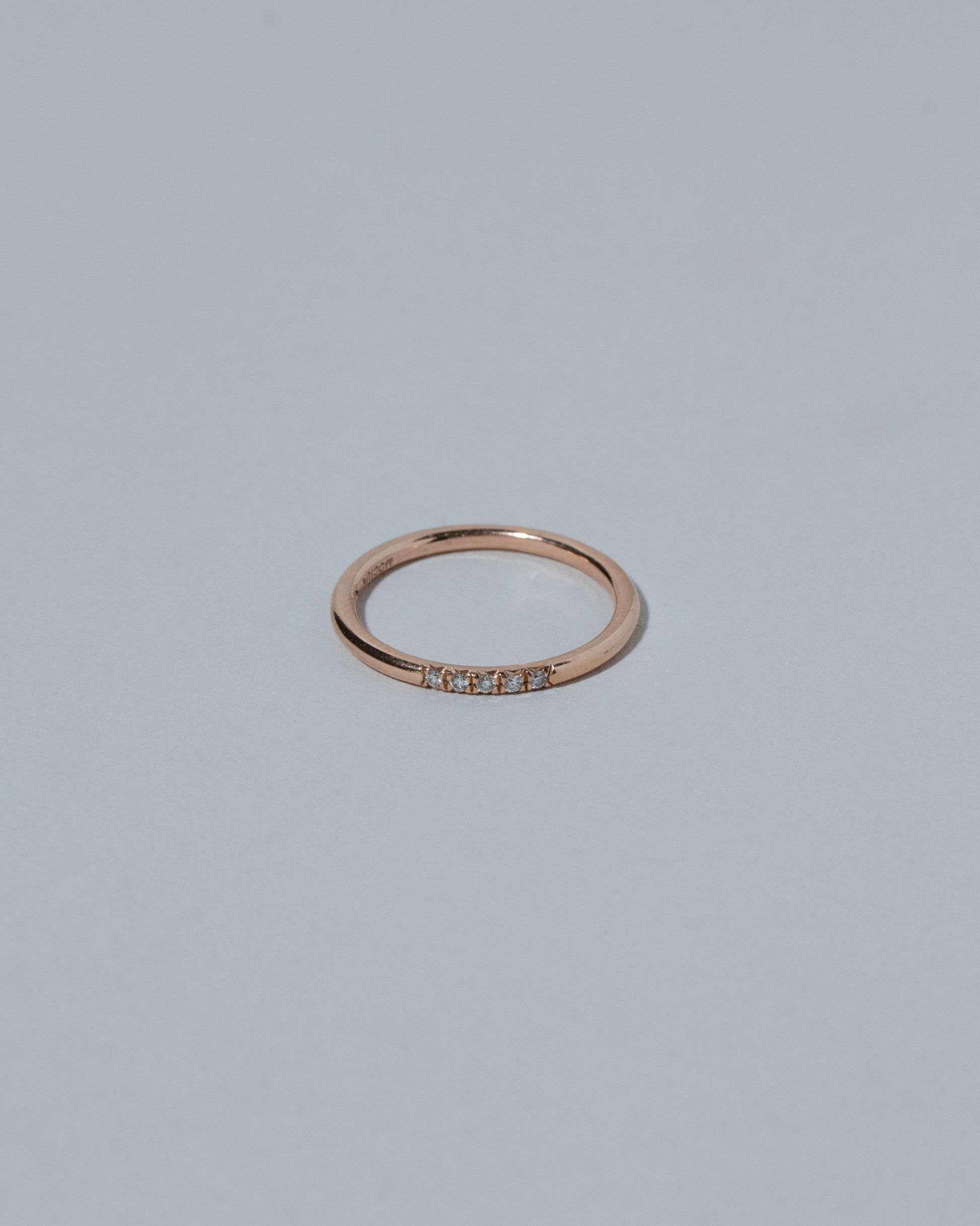 Rose Gold Five Stone Dot Band on light color background.