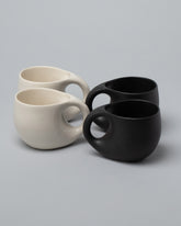 Dust and Form Mugs Set, including the Large Charcoal and Large Cream Comfort Mugs on light color background.