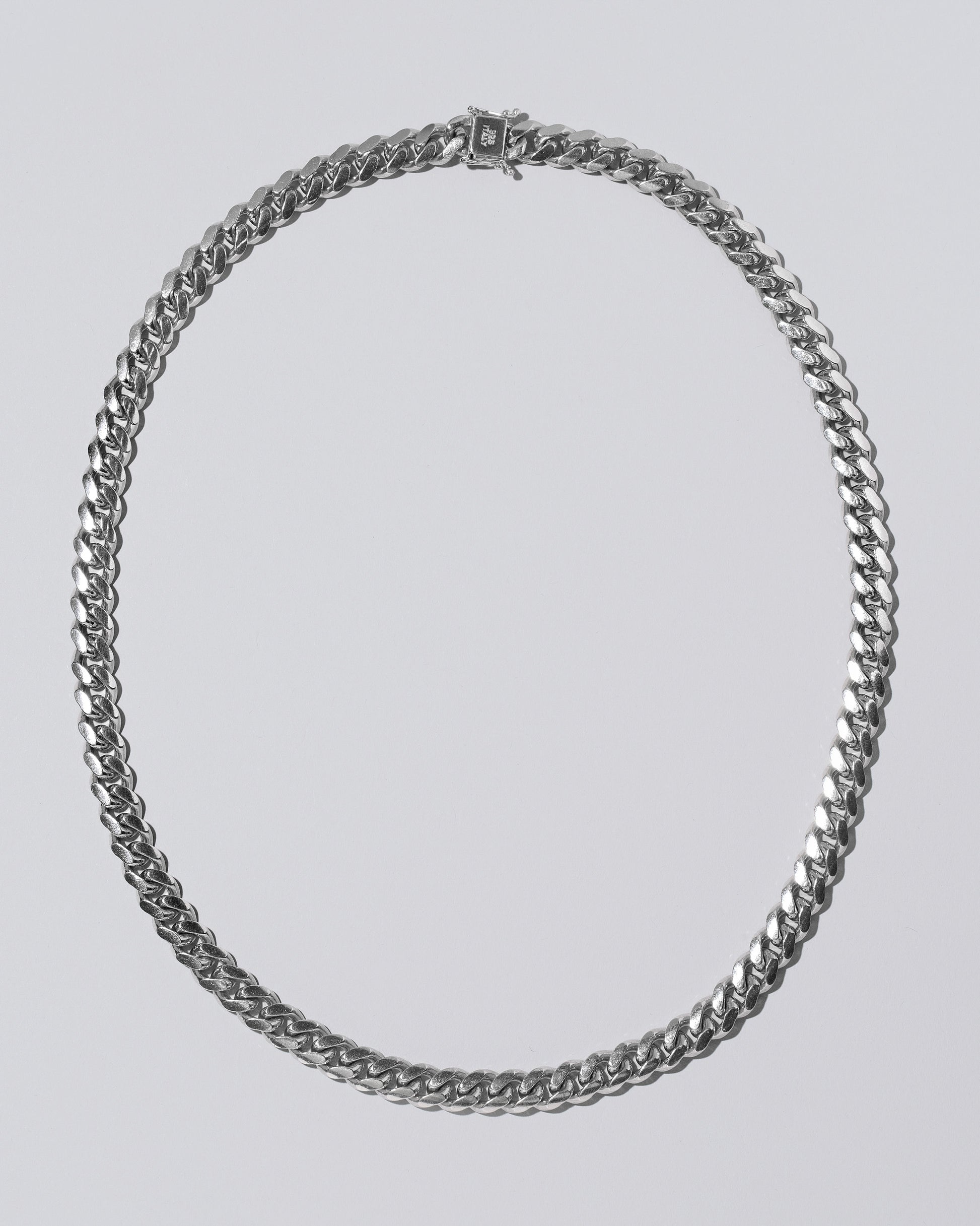 Silver Cuban Chain on light color background.