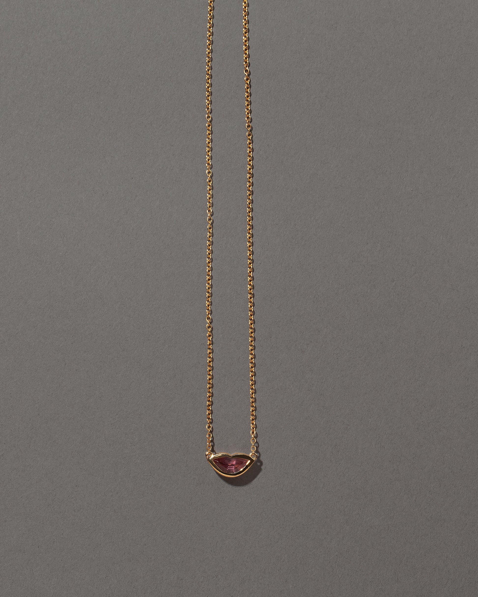 Peach Spinel Lover's Kiss Necklace on grey color background.