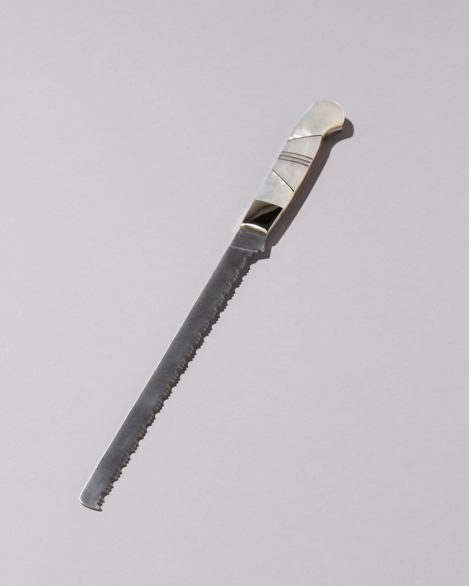 Santa Fe Stoneworks Mother of Pearl Bread Knife on light color background.