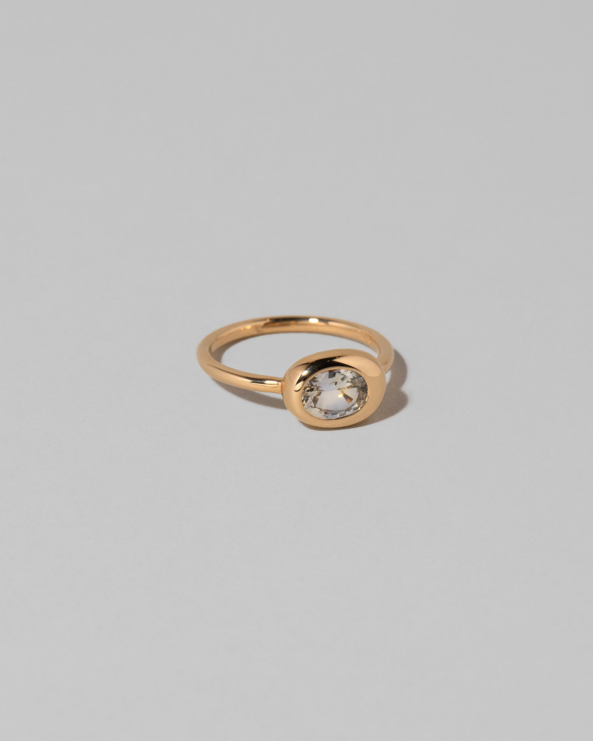 View from the side of the Oval Sapphire Equalize Ring on light color background.