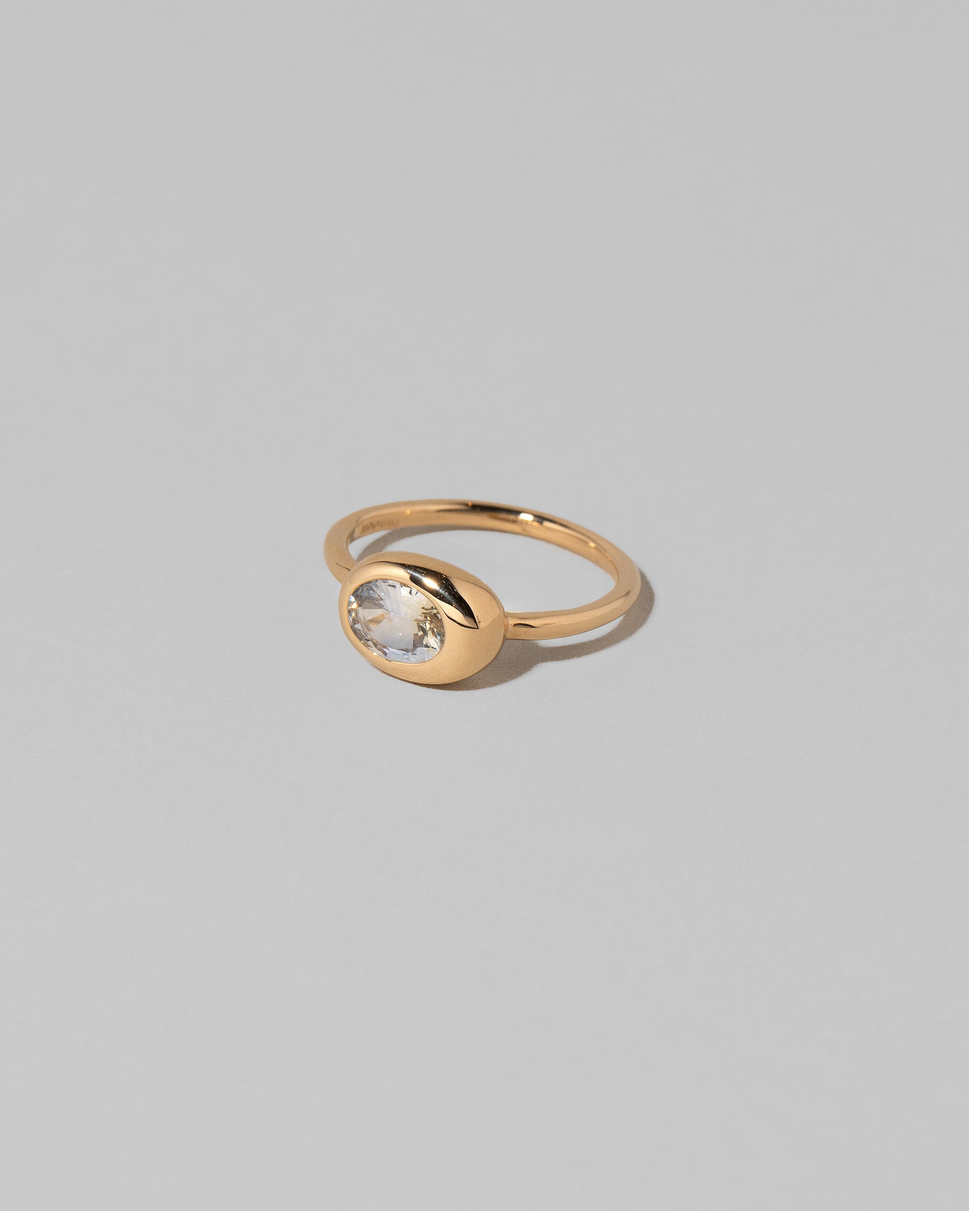 View from the side of the Oval Sapphire Equalize Ring on light color background.