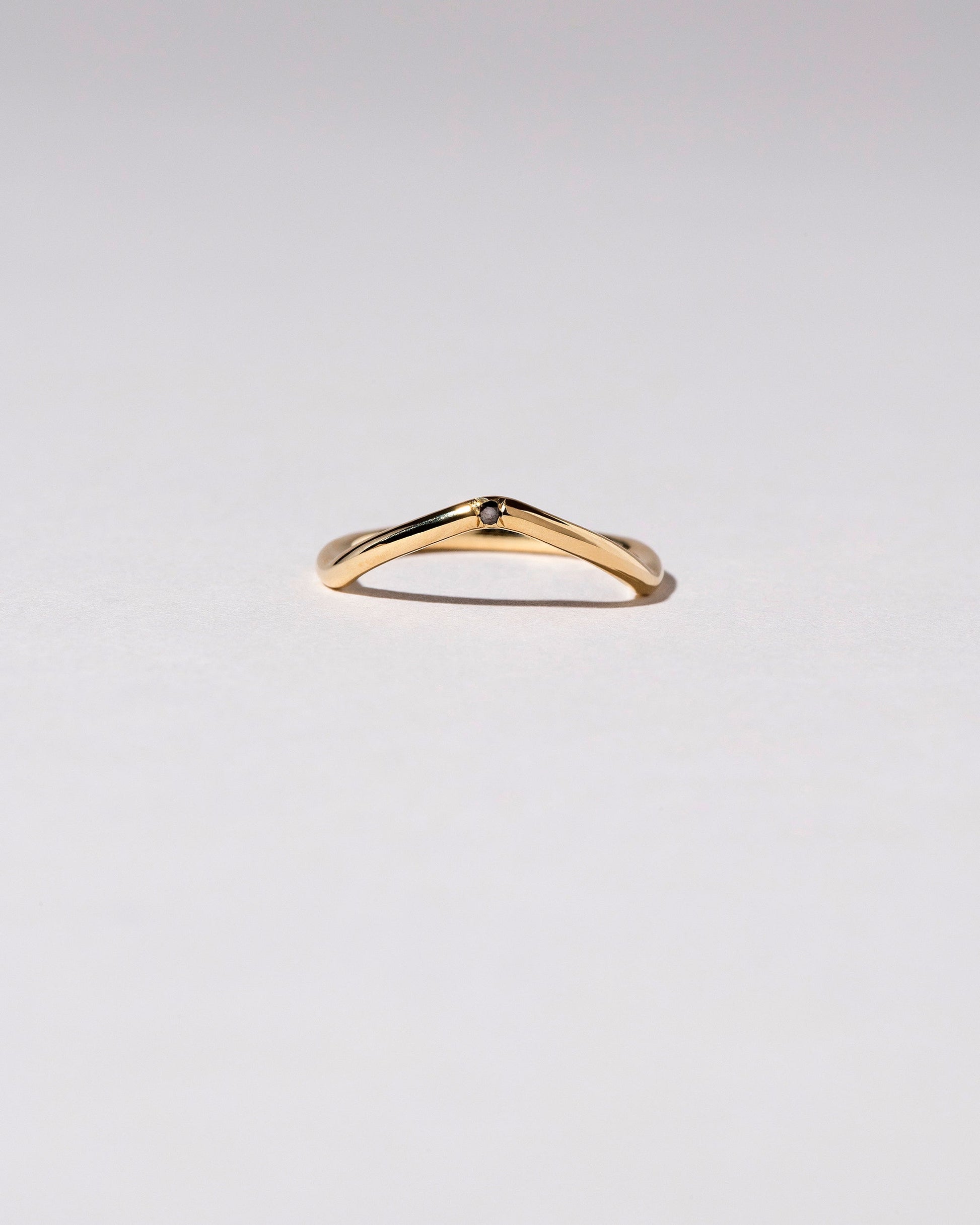 Gold Black Diamond Single Stone Low Peak Band on light color background.