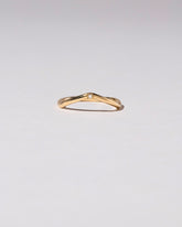 Gold Three Stone White Diamond Low Peak Band on light color background.