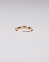 Gold Five Stone Garnet Low Peak Band on light color background.