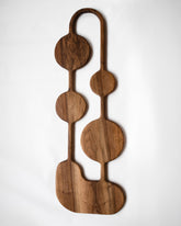 Lucas Castex No. 02 Hand-Carved Walnut Wood Serving Board on light color background.