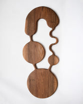 Lucas Castex No. 03 Hand-Carved Walnut Wood Serving Board on light color background.