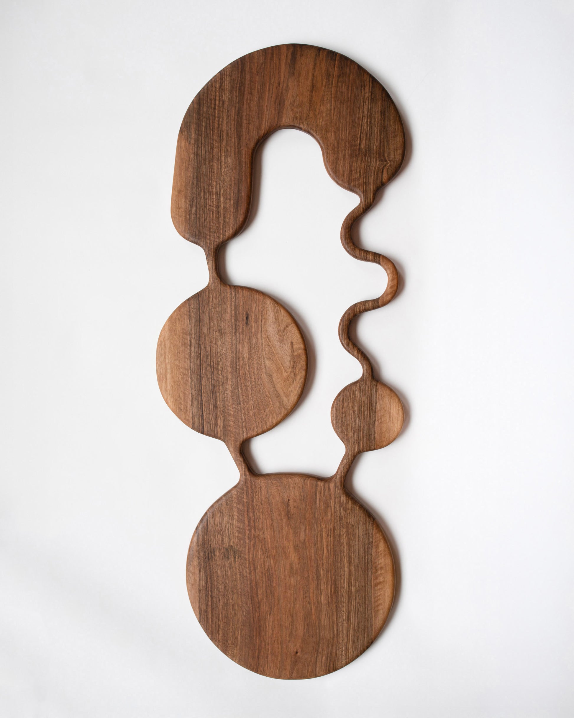 Lucas Castex No. 03 Hand-Carved Walnut Wood Serving Board on light color background.