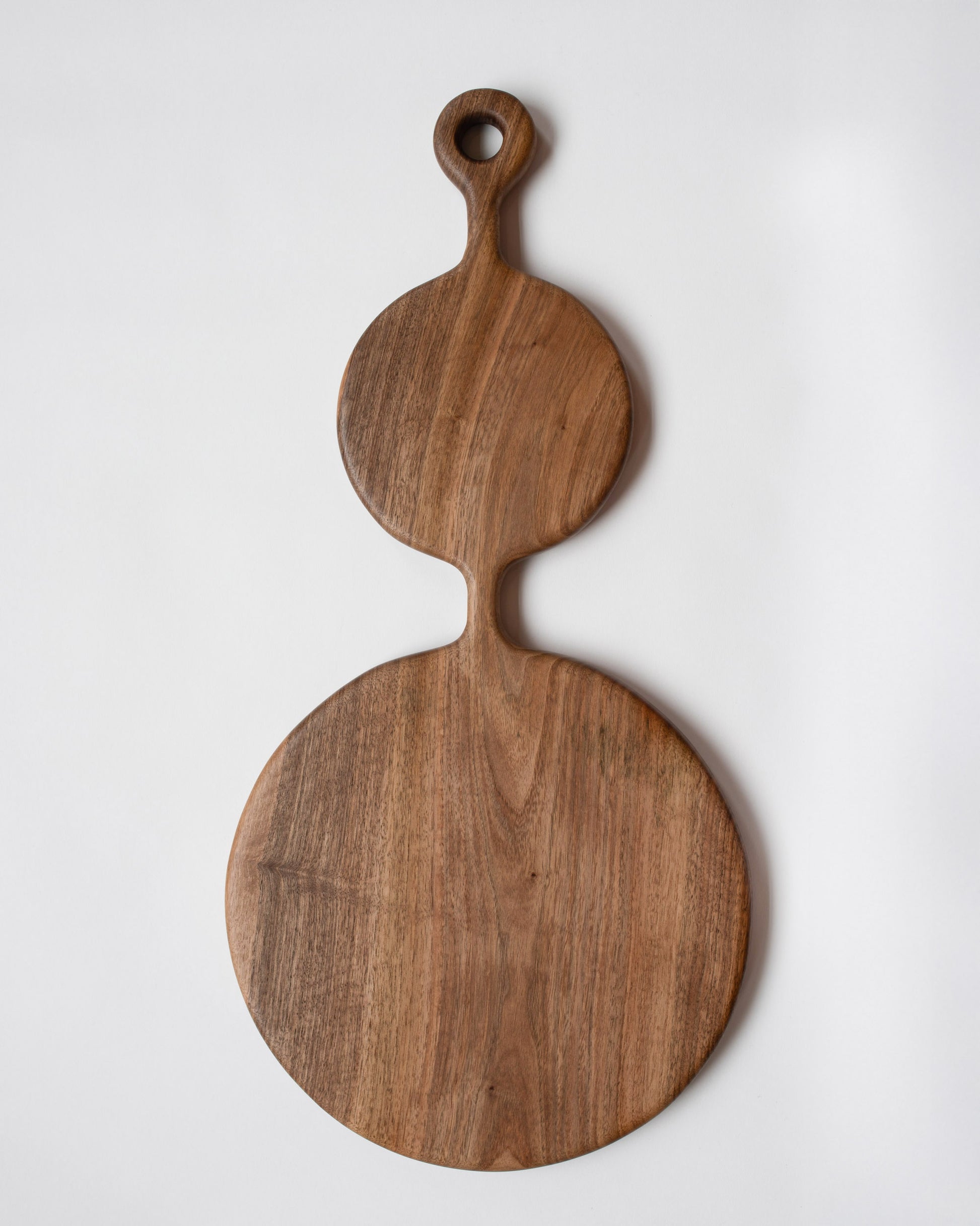 Lucas Castex No. 06 Hand-Carved Walnut Wood Serving Board on light color background.